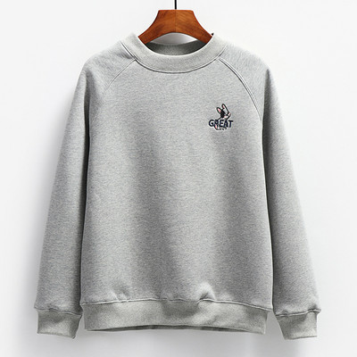 Ένα καθαρό μοντέλο γυναικείου φούτερ με κεντημένη επιγραφή και οβάλ λαιμόκοψη