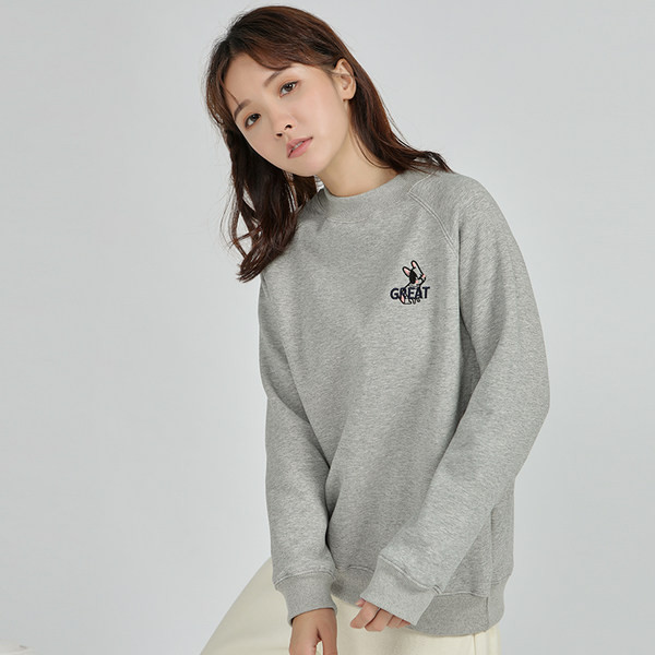 Ένα καθαρό μοντέλο γυναικείου φούτερ με κεντημένη επιγραφή και οβάλ λαιμόκοψη