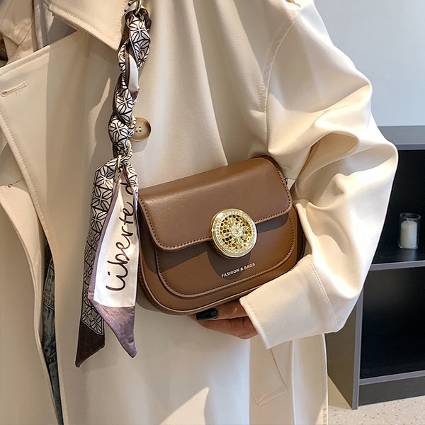 Modern kézitáska fém csattal és sállal