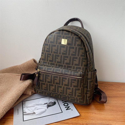 Női bőr hátizsák elülső zsebbel és fém elemmel