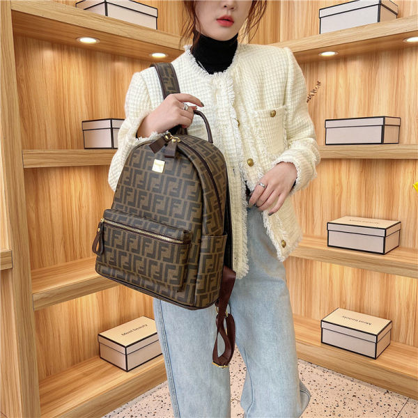 Női bőr hátizsák elülső zsebbel és fém elemmel