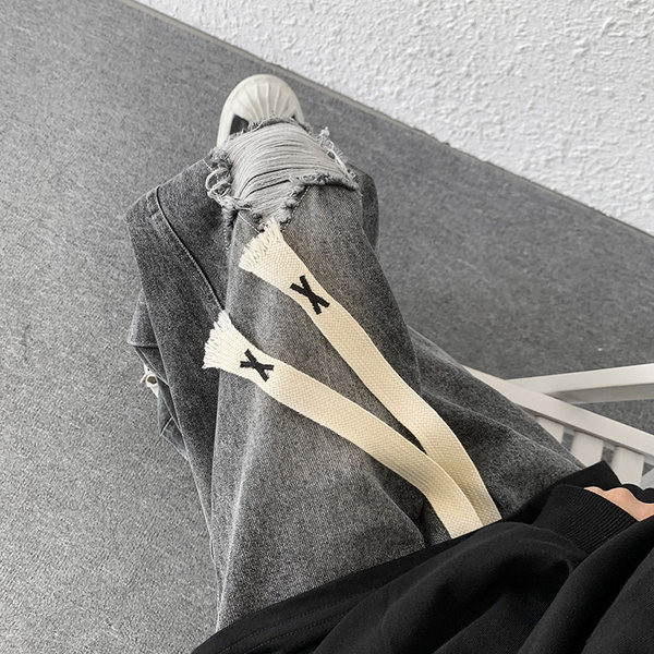 Laia istuvusega meeste teksad, millel on rebenenud motiivid ja paelad