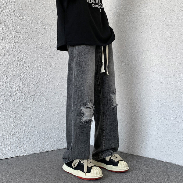 Laia istuvusega meeste teksad, millel on rebenenud motiivid ja paelad