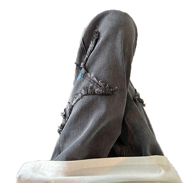 Széles szabású férfi farmernadrág szakadt motívumokkal és feliratokkal