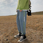 Värvilise kaunistuse ja kirjaga meeste teksad