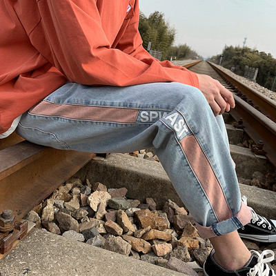 Värvilise kaunistuse ja kirjaga meeste teksad