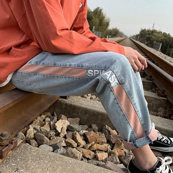 Värvilise kaunistuse ja kirjaga meeste teksad