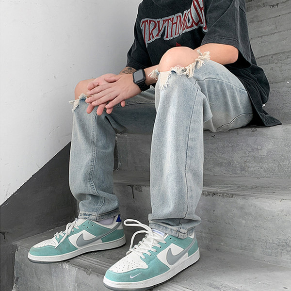 Meeste sirge säärega teksapüksid, millel on rebitud motiivid ja tasku