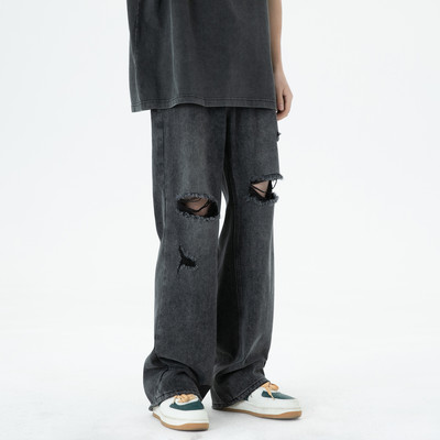 Széles szárú férfi farmernadrág szakadt motívumokkal és zsebbel