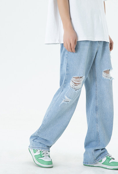 Széles szárú férfi farmernadrág szakadt motívumokkal és zsebbel