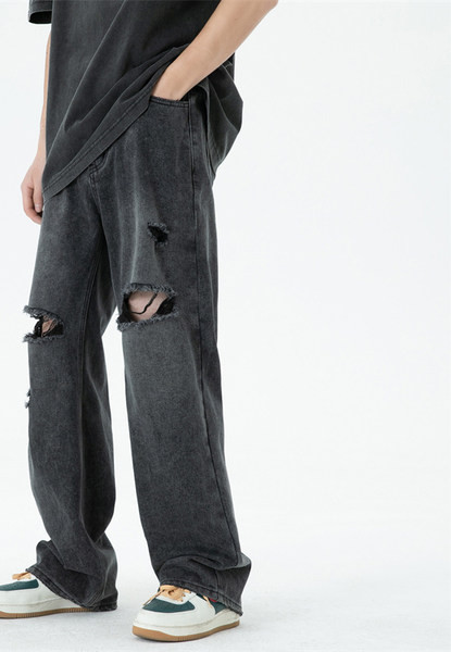 Széles szárú férfi farmernadrág szakadt motívumokkal és zsebbel