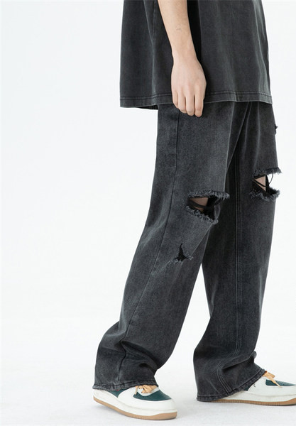 Széles szárú férfi farmernadrág szakadt motívumokkal és zsebbel