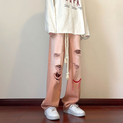 Szakadt motívumokkal és hímzéssel ellátott férfi farmer