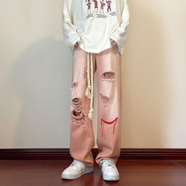 Szakadt motívumokkal és hímzéssel ellátott férfi farmer