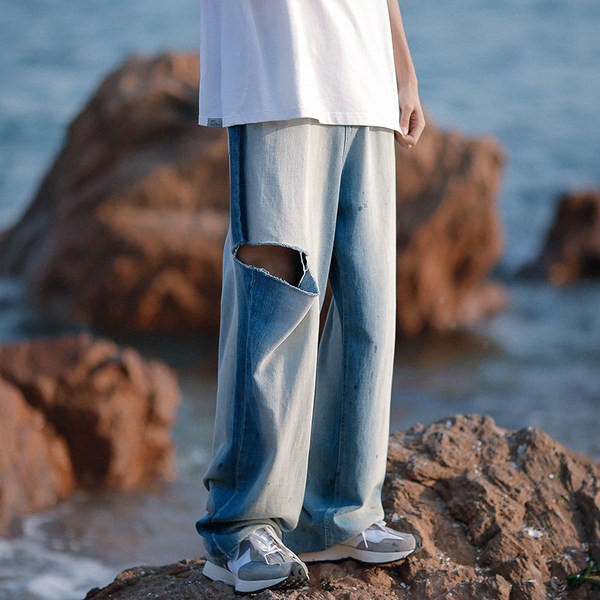 Laia säärega meeste teksad, millel on rebenenud motiivi ja tasku