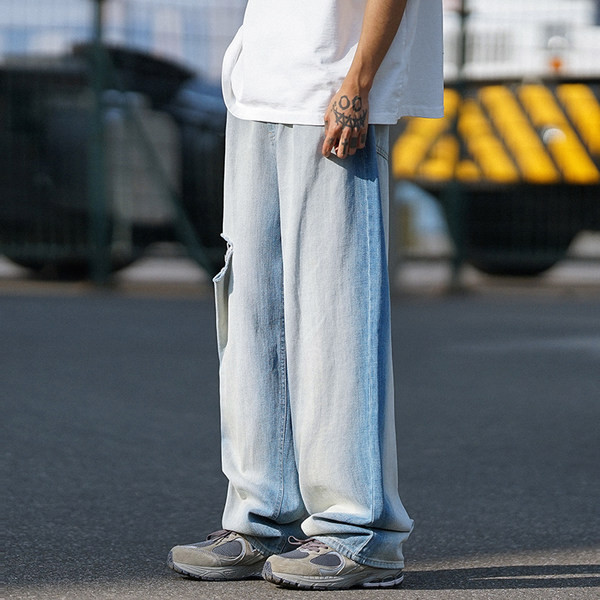 Laia säärega meeste teksad, millel on rebenenud motiivi ja tasku