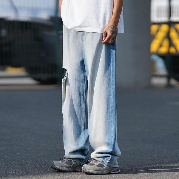 Laia säärega meeste teksad, millel on rebenenud motiivi ja tasku