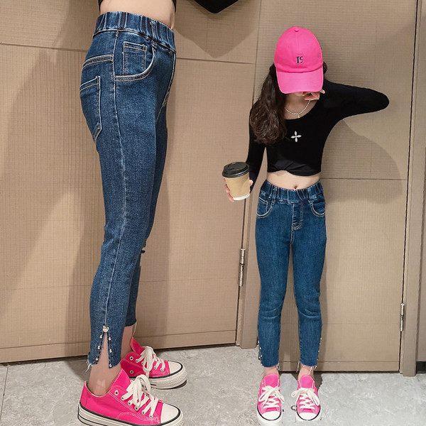 Magas derekú, szűk lány farmer, fémes részletekkel