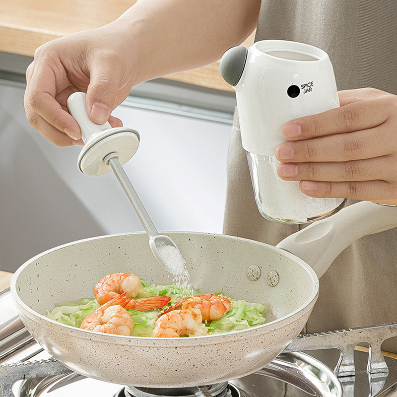 2 vnt. skaidrūs prieskonių stiklainiai su šaukštu, drėgmei atsparūs plastikiniai indeliai su prieskoniais, virtuvės čili miltelių druskos plaktuvas.