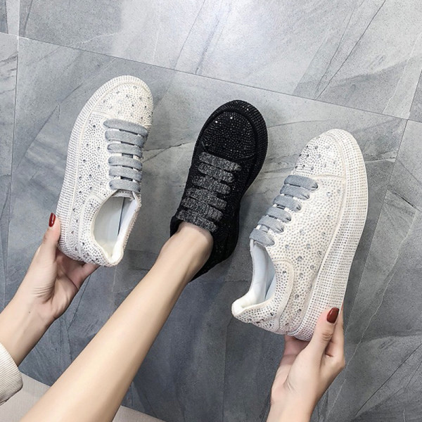 Moteriški sportbačiai ant platformos su akmenukais