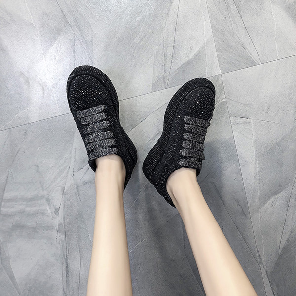 Moteriški sportbačiai ant platformos su akmenukais