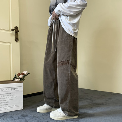 Pánske nohavice širokého modelu s vyšívanými nápismi a šnúrkami a vreckom