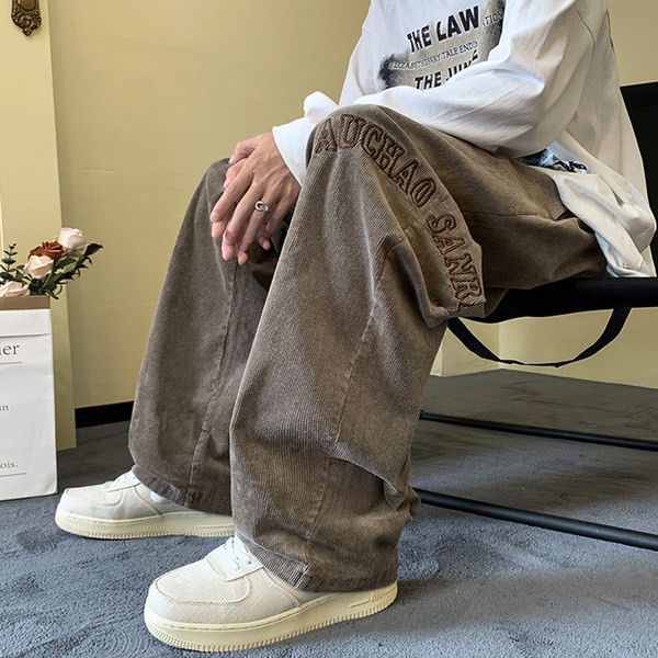 Pánske nohavice širokého modelu s vyšívanými nápismi a šnúrkami a vreckom