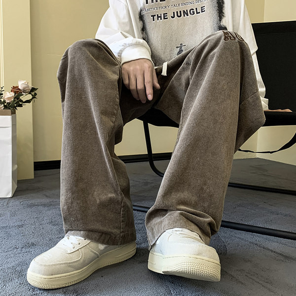 Pánske nohavice širokého modelu s vyšívanými nápismi a šnúrkami a vreckom