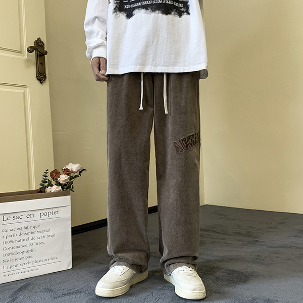 Pánske nohavice širokého modelu s vyšívanými nápismi a šnúrkami a vreckom