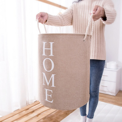 Sulankstomas skalbinių krepšelis, apvalus su rankenomis.