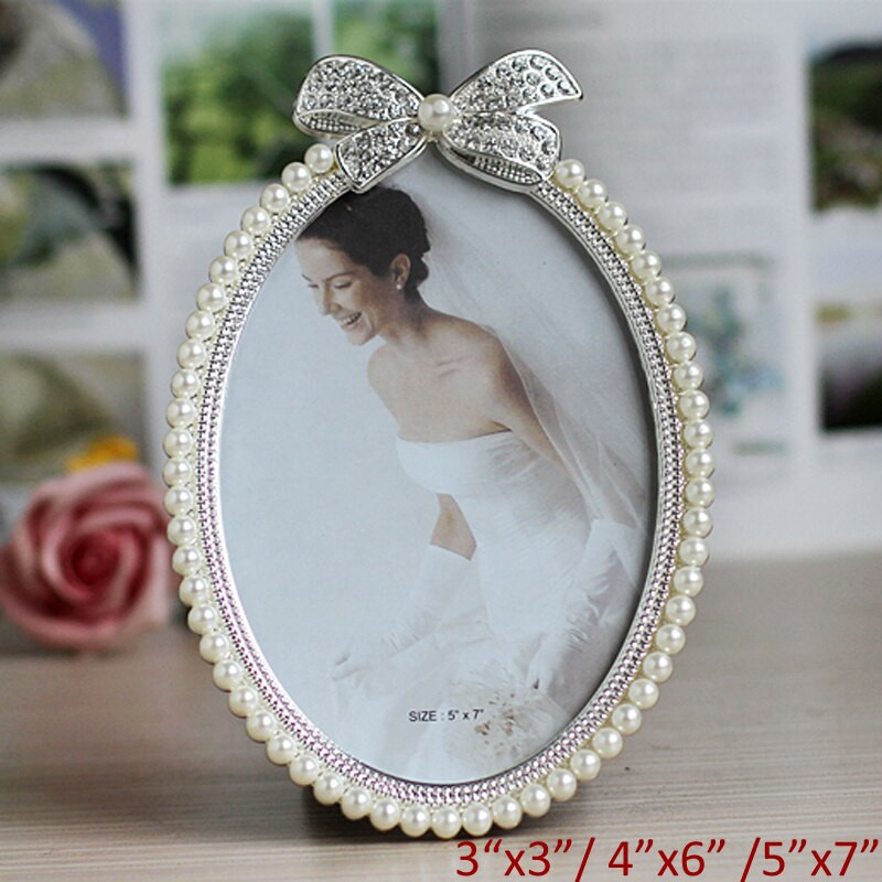 Blizgus sidabru padengtas cinko lydinio paveikslų rėmelis su baltais perlais ir skaidriais kalnų krištolais papuošta 3 dydžių apvalių ovalių formų juostele